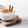 arroz con leche rice pudding with cinnamon clay bowl white marble top view scaled